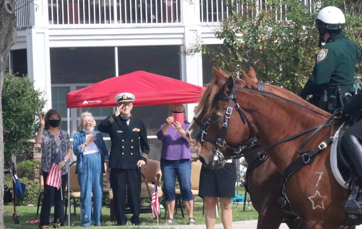 Retired Navy Lt. Cmdr. Roger Quisenberry, a World War II veteran, salutes mounted Manatee County Sheriff’s deputies Wednesday during a parade that celebrated his 100th birthday.