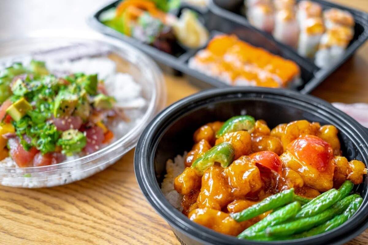 This Bento Asian Kitchen + Sushi food spread includes, clockwise from top, Sushi Combo Box, Pao Pao Chicken Rice Bowl, and an Hawaiian Poke Bowl.