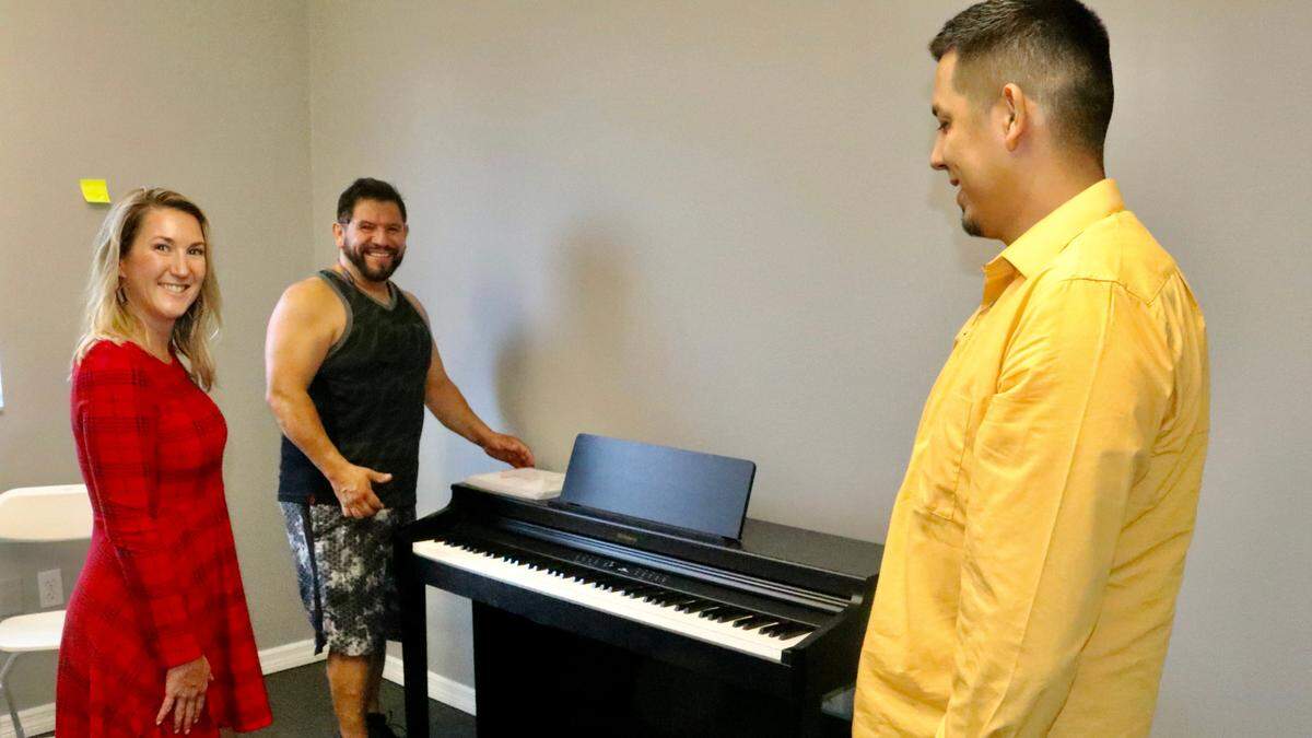 Jenny Townsend approves of the placement of a digital piano from Pritchard’s Pianos by Laurencio Lecona (left) and Exxon Lopez, shown 7/13/2022. Townsend’s school, Music Compound MAN, opens in Bradenton on July 18 with kids summer camp.