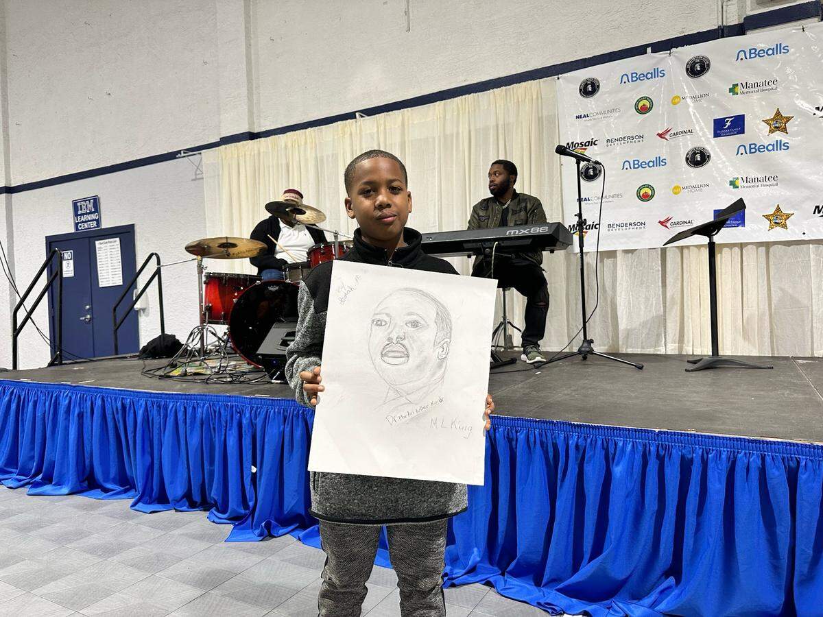 Josiah McNeal, 10, a student at James Tillman Elementary, Stands before the crowd at the Martin Luther King Jr Talent show held at the Palmetto Youth Center. He’s holding a picture he drew of King.