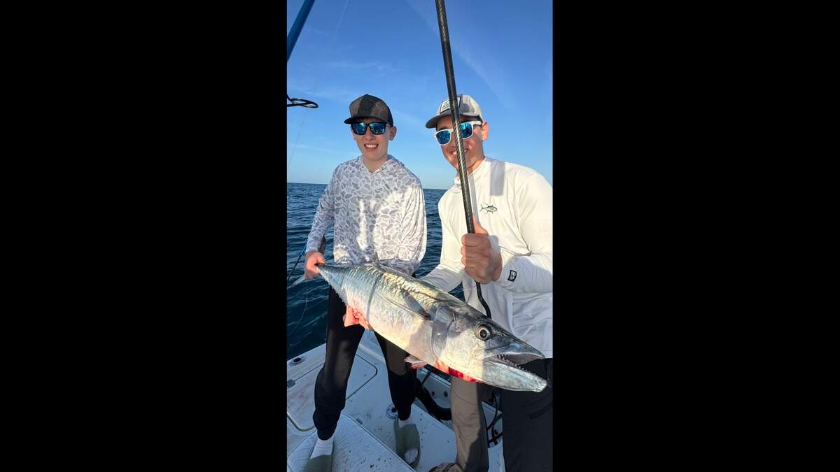 Dallas and Colton Kielty pose with a kingfish caught while fishing with Captain Jonathan Soultatos.