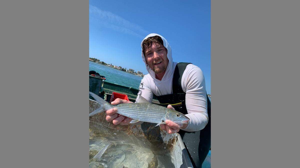 Trever Flathman, a commercial fisherman from Bradenton, with one of the larger bonefish he seines and releases in Tampa Bay.