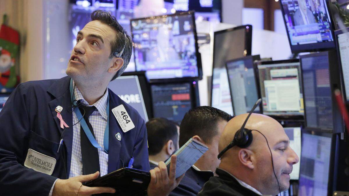 Gregory Rowe, left, with Livermore Trading Group, keeps an eye on stock prices at the New York Stock Exchange, Friday, Jan. 8, 2016. A rebound in Chinese stocks helped shore up the mood in global stock markets Friday in the run-up to U.S. jobs data. (AP Photo/Mark Lennihan)