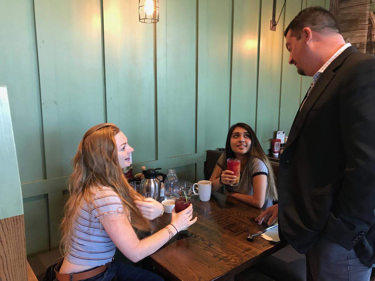 First Watch CEO Chris Tomasso chats with lunch guests Winter Van Horne, left, and Alena Berry.