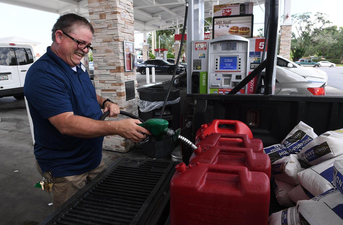 Scott LaMay happily fills some cans with diesel fuel at one WaWa station in Bradenton as residents get prepared for the possible approach of Hurricane Dorian Friday.