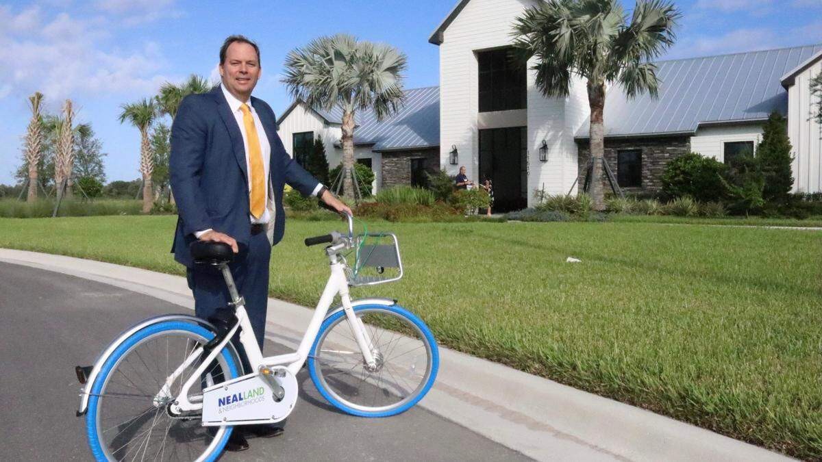 John Neal, president of Neal Land & Neighborhood, is shown on 9/27/2020 with one of the bicycles that residents of North River Ranch in Parrish can use to get around their community, which is being designed to have about 24 miles of trails and paths. This week he confirmed that a hospital and assisted living facility are planned for the village center.