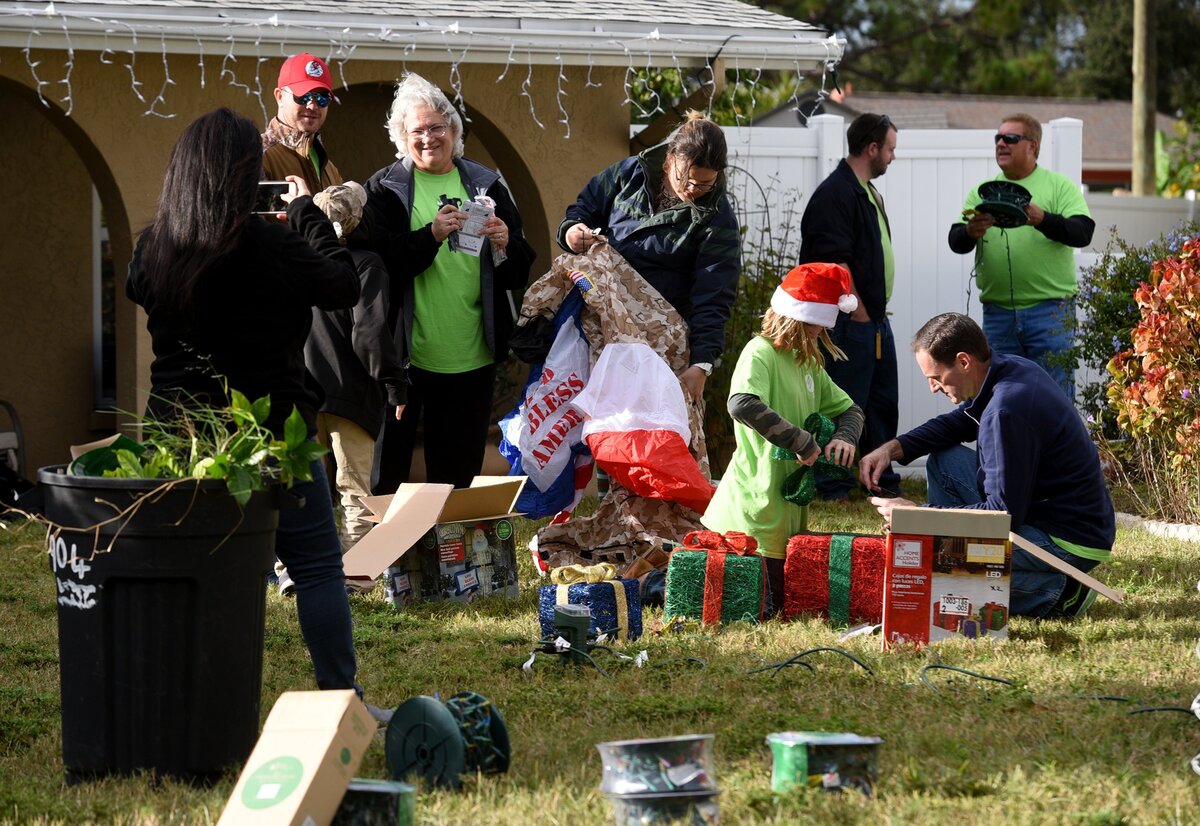 Florida Power and Light volunteers work to decorate and surprise a veteran and his family as a Christmas surprise in Bradenton Monday.