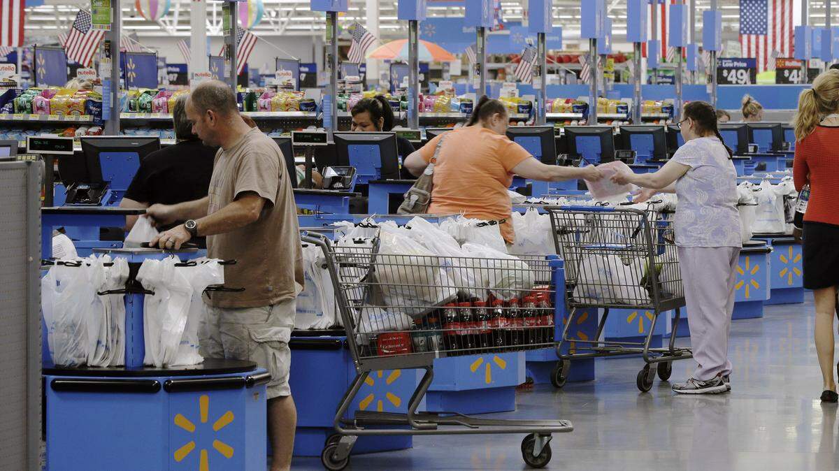 FILE - In this June 4, 2015 file photo, shoppers check out at a Wal-Mart Supercenter store in Springdale, Ark. Economists forecast that retail sales rose a seasonally adjusted 0.3 percent last November, according to a survey by FactSet on Friday, Dec. 11, 2015. This would be a modest acceleration from a gain of 0.1 percent in October and flat sales in September. (AP Photo/Danny Johnston)