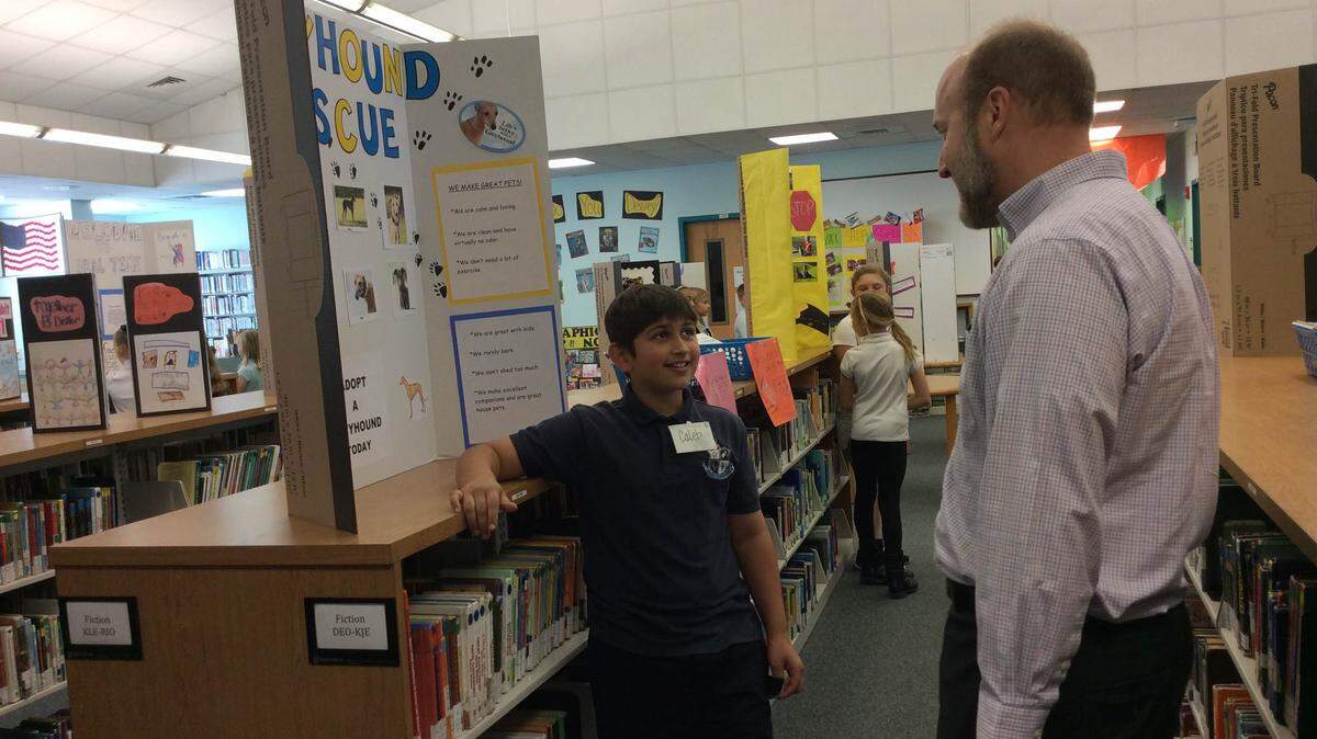 Caleb Dickerson, a 10-year-old fifth-grade student at Rowlett Academy for Arts and Communication, talks with Blalock Walters lawyer Fred Moore at the school on March 13, 2016. MEGHIN DELANEY / Bradenton Herald