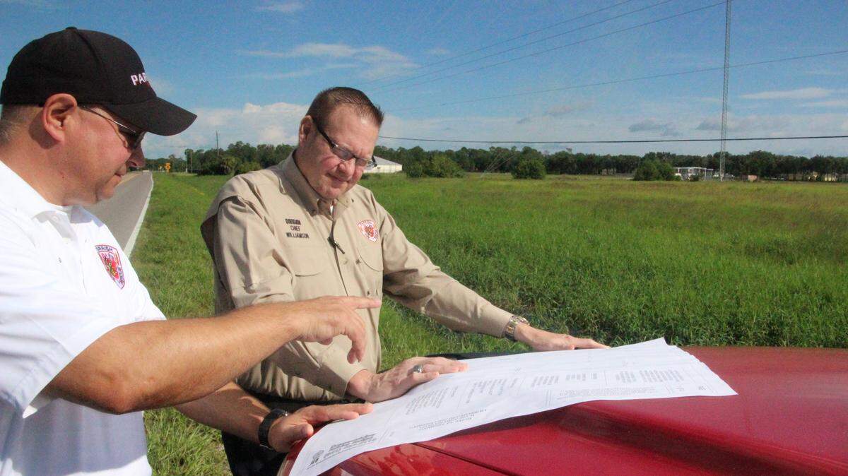 Parrish Fire Chief Stacey Bailey, left, and Division Chief Michael Williamson look at plans for the district’s second fire station, which is proposed for State Road 675 in Foxbrook.