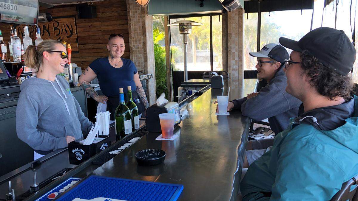 Jessica Haskett, left, and Faye Wallis chat with Anthony Tino and Chance Lenz at Tarpon Bay Grill’s tiki bar.