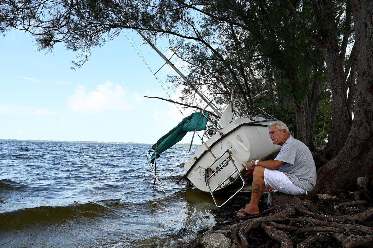 Everett Hodapp sits with his sailboat, ‘Mist,’ which was buffeted ashore during Hurricane Idalia. Hodapp was given the 28 ft. Seafarer and was going to live on it before the storm’s damage.