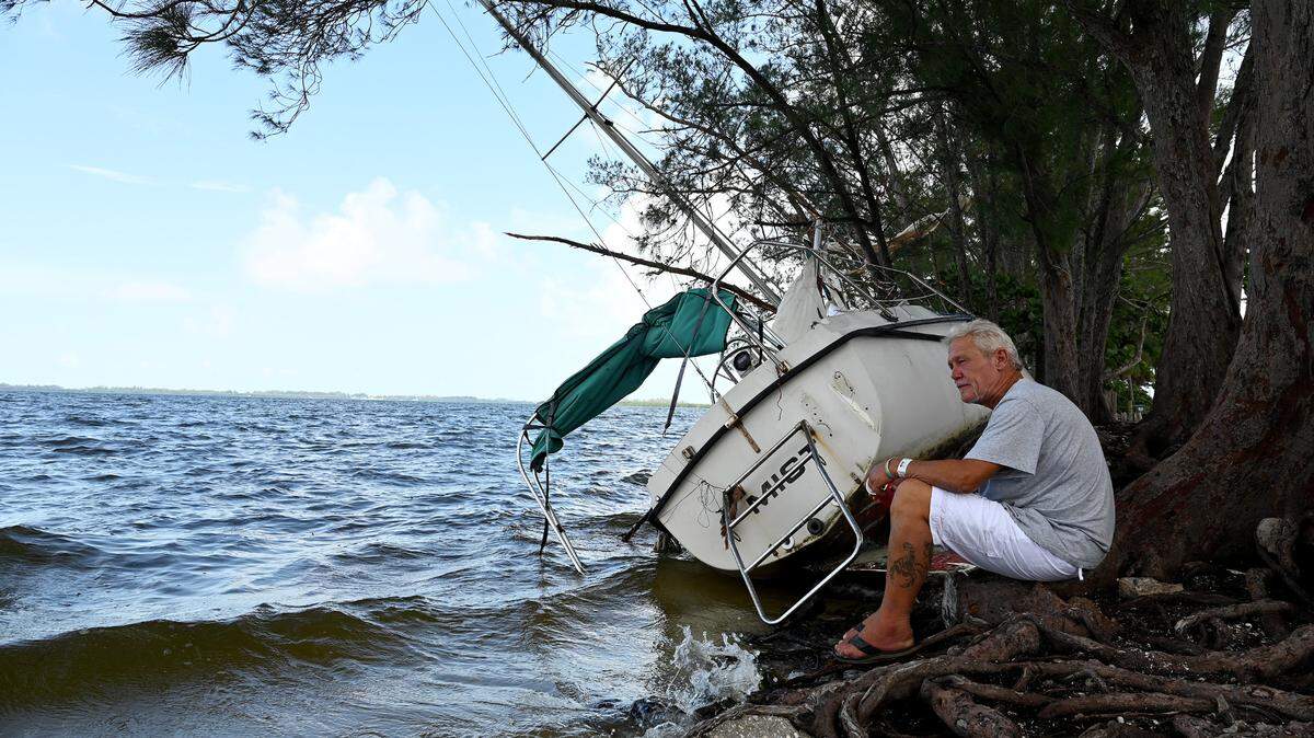 Everett Hodapp sits with his sailboat, ‘Mist,’ which was buffeted ashore during Hurricane Idalia. Hodapp was given the 28 ft. Seafarer and was going to live on it before the storm’s damage.