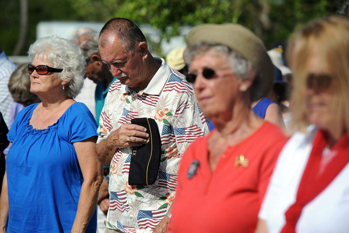 A crowd stands in respectful silence during the annual Memorial Day Service held by the Manatee Veterans Council at the Veterans Monument in Bradenton.