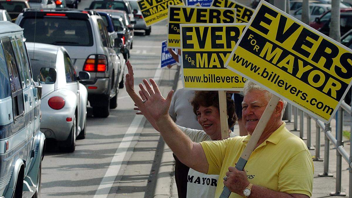Mayoral candidate Bill Evers campaigns with his supporters on Manatee Avenue the day before the city election in 2004.