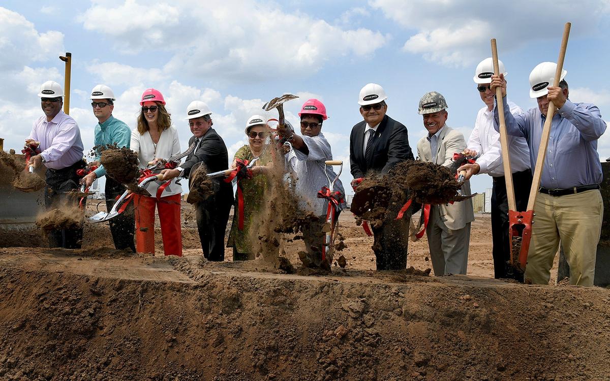 School board members and dignitaries ceremonially throw dirt at the groundbreaking for a new middle school named for Mona Jain which took place Friday afternoon.