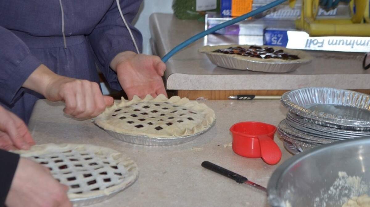 The women put together the many pies assembly-line style; here, the crimpers go to work.