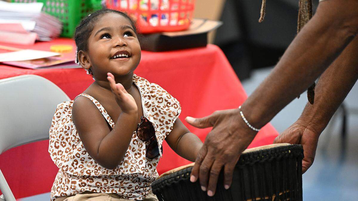 Ava C., 3, looks up to Brother Maceo, drumming artist, as children celebrate Juneteenth through music and art Friday at the Manatee County Central Library during the 7th annual Juneteenth Reading Conference created by Rosalyn Walton Education and Enrichment Services, Inc.