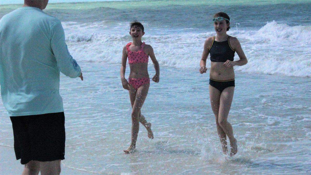 Greta and Ivy Betz ran out of the surf to greet their father, Kip Betz on Monday. The family regularly visits Anna Maria Island from Bethel, Conn.