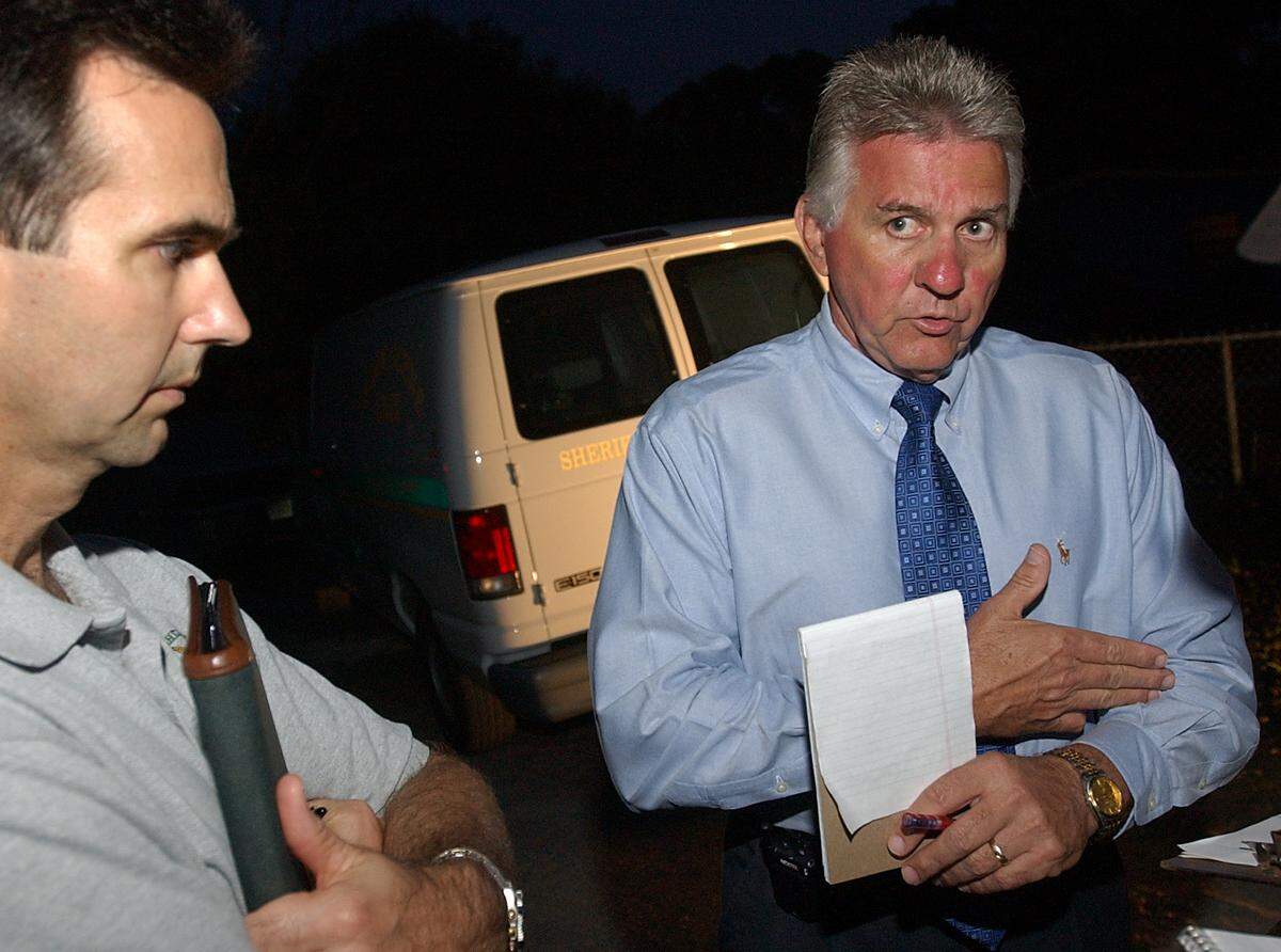 Then Manatee County Sheriff Charlie Wells, right, accompanied by sheriff’s spokesperson Dave Bristow, describes how an assailant seriously wounded a sheriff’s deputy in the arm with a large axe on the evening of March 6, 2004 near the intersection of 12th Street Court East and 32nd Avenue East in Bradenton.