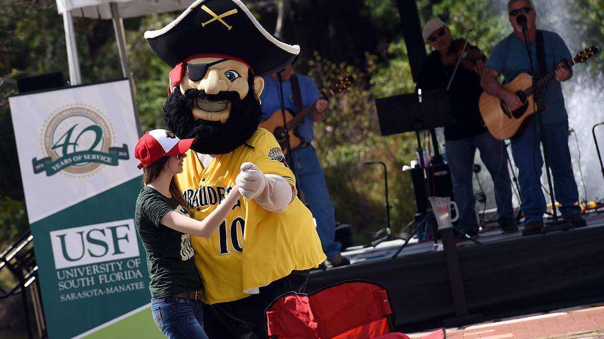 Marty the Marauder dances with Tiffany Williams at USF Sarasota-Manatee's festival to celebrate 40 years service to the area. 
 TIFFANY TOMPKINS/Bradenton Herald