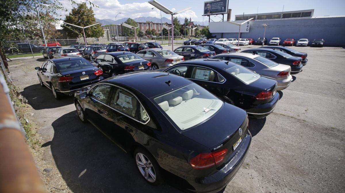 Volkswagen diesel cars are parked in a storage lot near a VW dealership in Salt Lake City last month. Volkswagen almost inevitably will have to compensate owners of diesel cars equipped with emissions-rigging software. Some legal experts say the automaker could be forced to buy back the cars altogether. AP Photo File