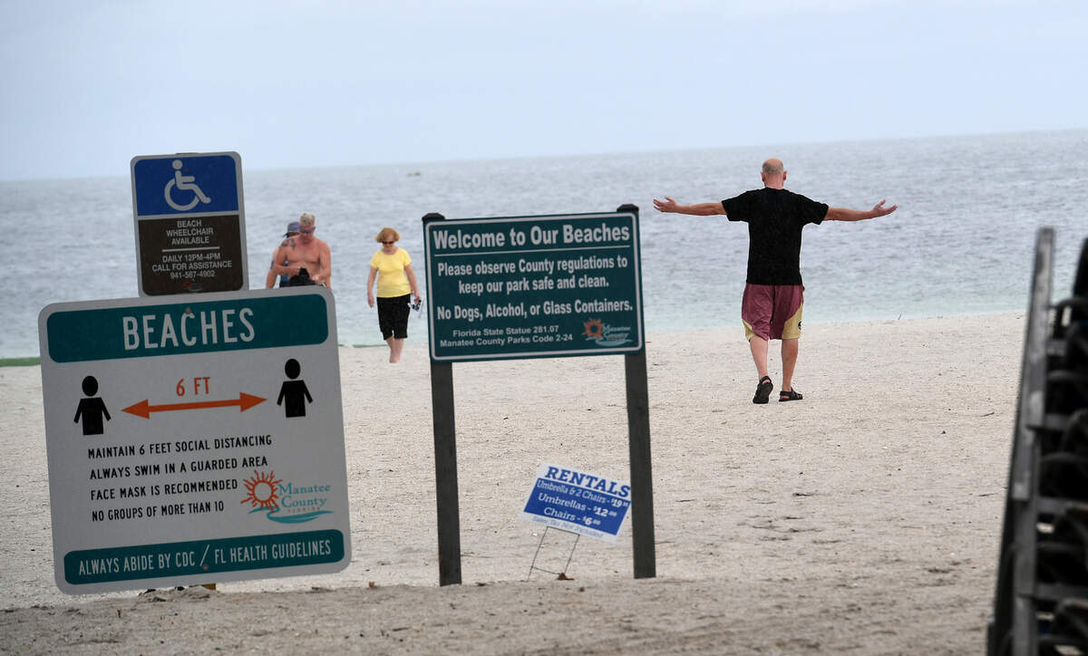 A visitor puts his arms out to feel the sprinkle of rain at Manatee Public Beach. Tropical storm warnings have been canceled for the time being in Manatee County.