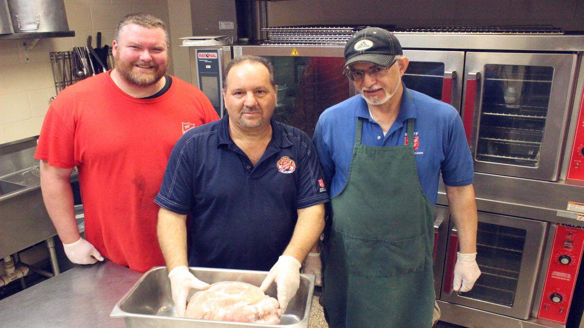 Jason Cooper, Tom Giglio, and Steve Gergle make final preparations Wednesday for the Salvation Army's Thanksgiving meal in Bradenton. 
 JAMES A. JONES JR./Bradenton Herald