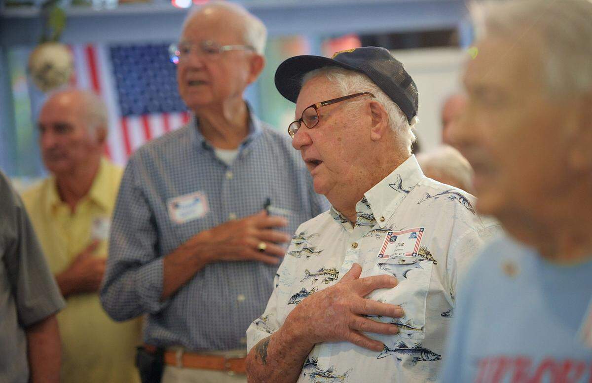 WWII veteran Joe Shannon sings The Star Spangled Banner while in the company of more than 80 veterans of “the greatest generation, who gathered in 2014 for an appreciation luncheon on the 70th anniversary of the Invasion of Normandy at the Anna Maria Oyster Bar Landside. John Horne said it is the greatest moment in his restaurant career.