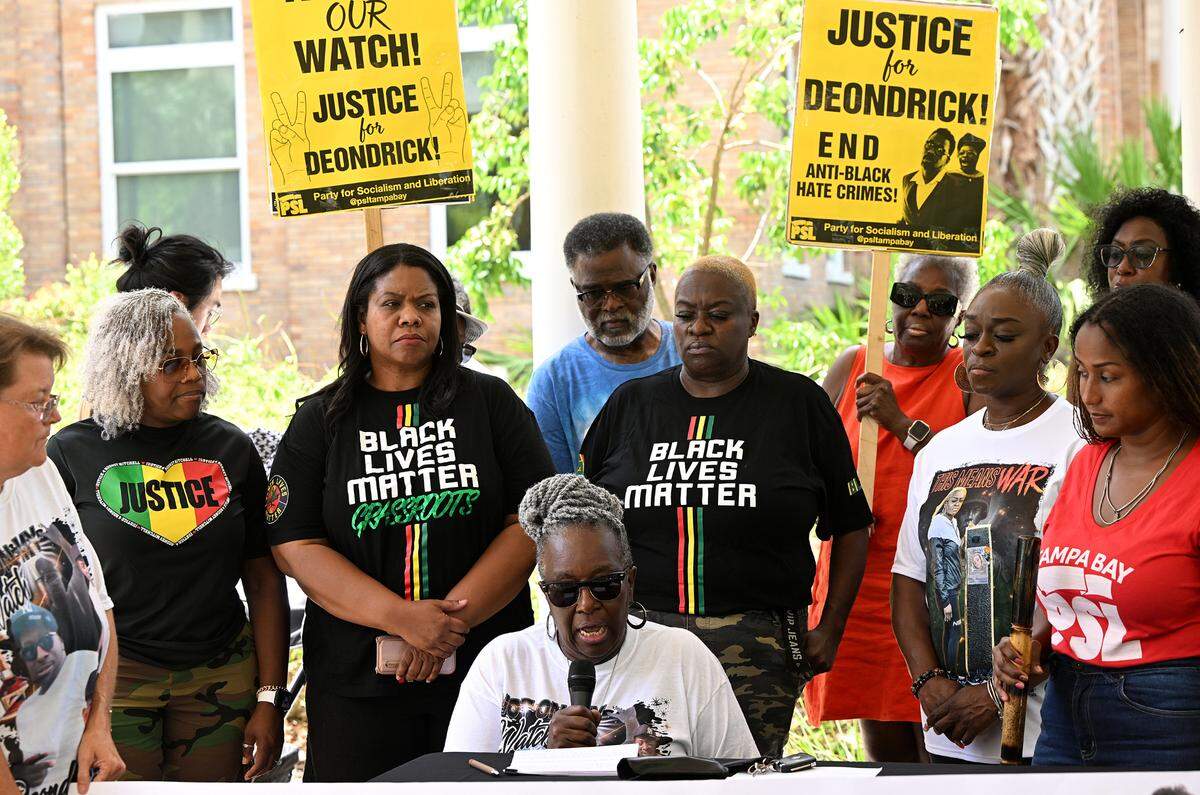 Angela Anderson, seated, speaks at a press conference held outside the Manatee County Judicial Center on June 9, 2025. Anderson’s family and supporters called on prosecutors to appeal the ruling which dismissed the case against the man who shot her son outside an Oneco bar.