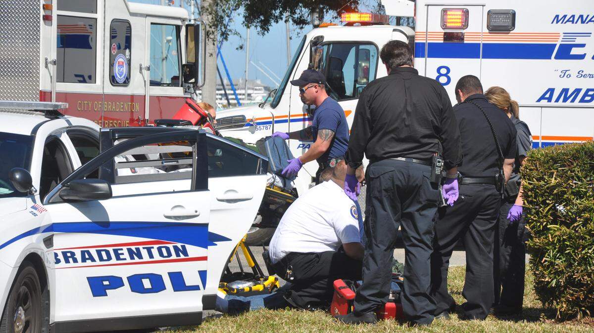 Bradenton police officers, paramedics and firefighters try to revive a man who reportedly suffered a seizure, possibly due to drugs, while under arrest just outside the Bradenton Police Department. KATE IRBY/Bradenton Herald