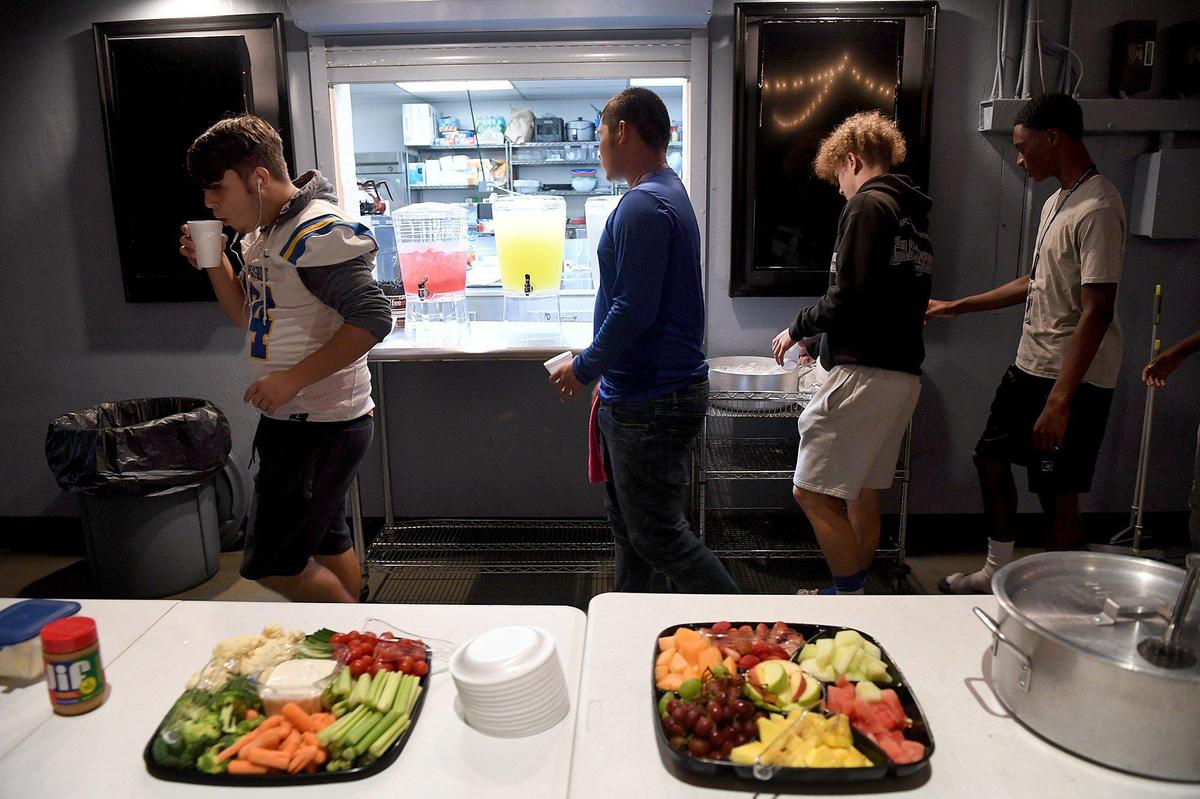 Bayshore High football players load up their plates with pancakes, bacon, fruit and vegetables at Church of the Cross, which prepares a pregame meal for them.