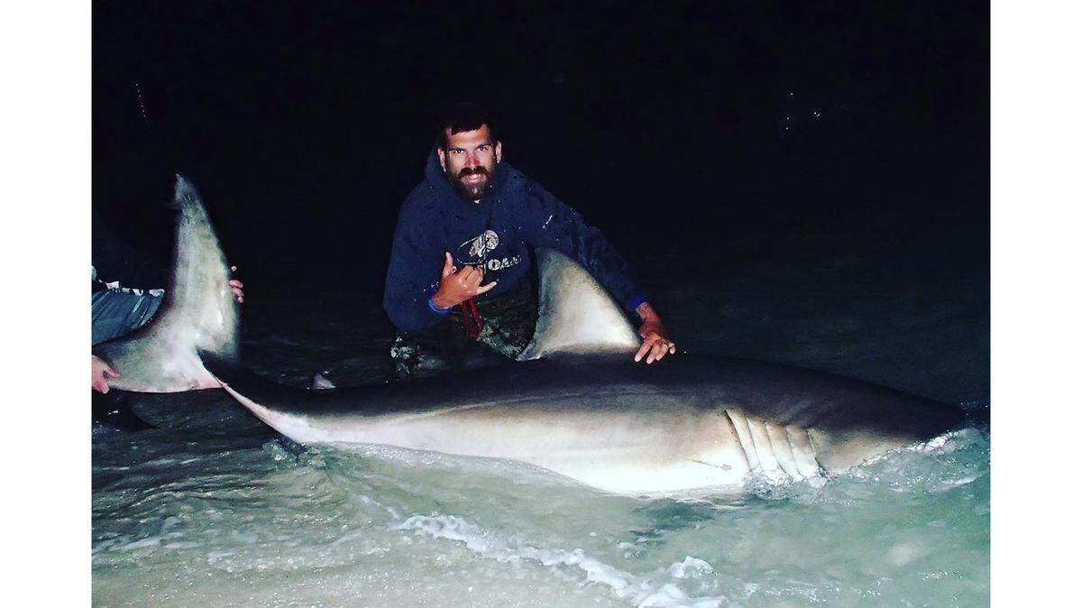 Adam Lopez with a great white shark he caught on Pensacola’s gulf shore in January of 2022.