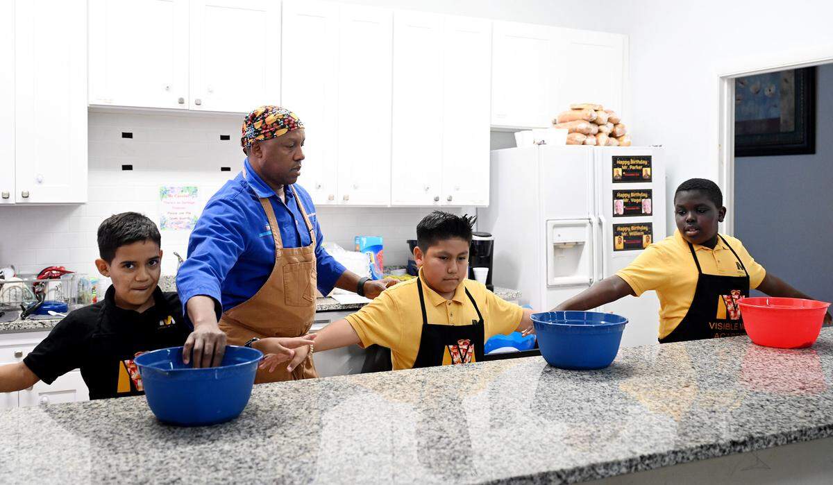 5th-grade students at Visible Men Academy learn how to make apple pies for Thanksgiving from celebrity chef Marvin Woods.