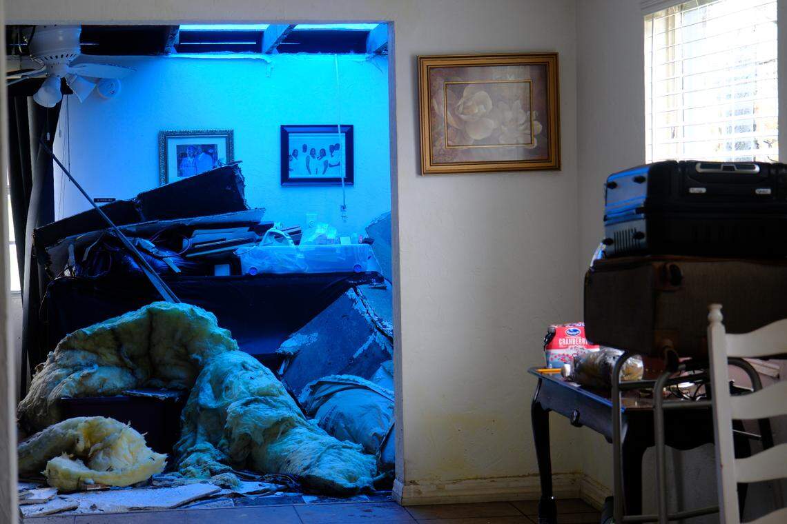 Tarp stretches over a chunk of roof that Hurricane Milton ripped off of Webster Hayes’ home in Rubonia, casting a blue glow over the wreckage.