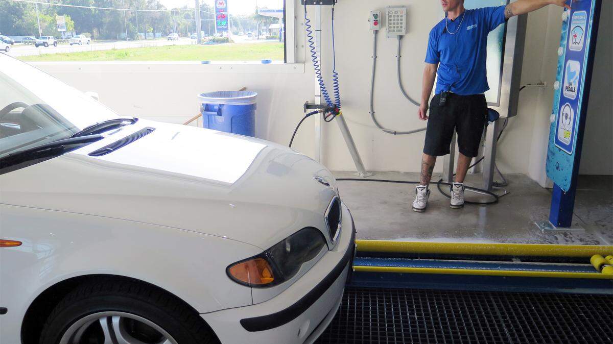 Alex Roussin instructs a driver heading into the automatic wash tunnel at Coastal Carwash. The business opened this week after six months of construction work. MATT M. JOHNSON/Bradenton Herald