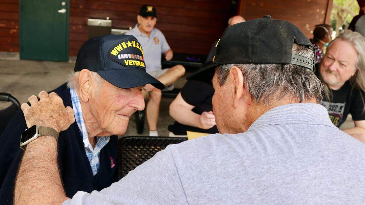 Paul Cote, who served as an Army officer in Vietnam, visits with Warren Pizzello, a World War II Navy veteran, on his 100th birthday March 15, 2022.