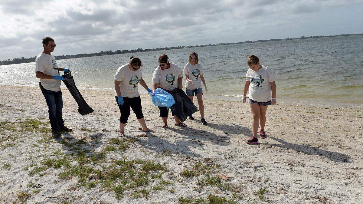Mark Smith, Moira Small, Sammy Chaney, Tammy Peters and Faith Chaney, representing a Girl Scout troop, participate Saturday in a Keep Manatee Clean event picking up trash at Palma Sola Causeway. 
 TIFFANY TOMPKINS/Bradenton Herald