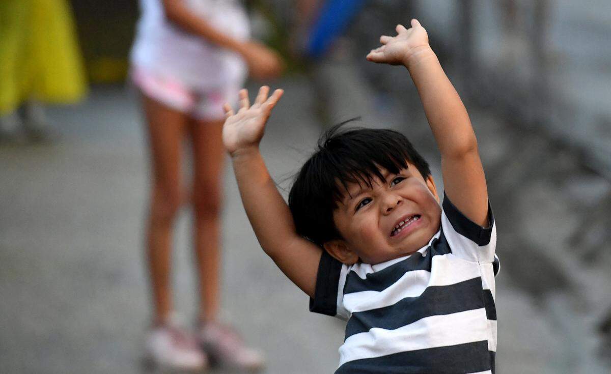 A small boy’s excitement isn’t dampened by the cancellation of the De Soto Parade as a few cars drove the route, some throwing beads.