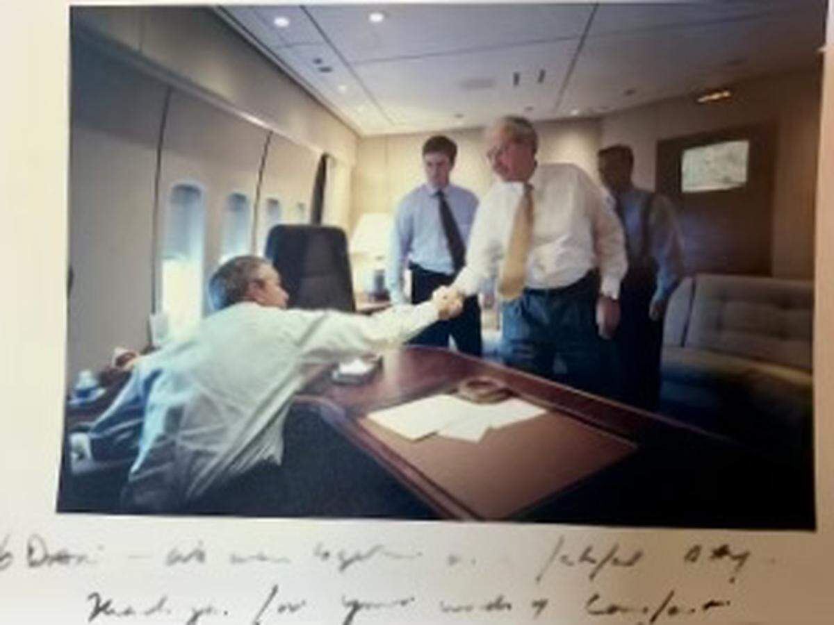 President George W. Bush reaches up to shake the hand of U.S. Rep. Dan Miller, R-Bradenton, after Air Force One left Sarasota Bradenton International Airport en route to Barksdale Air Force Base on Sept. 11, 2001. His inscription: “Dan, we were together on that fateful day. Thank you for your words of comfort.”
