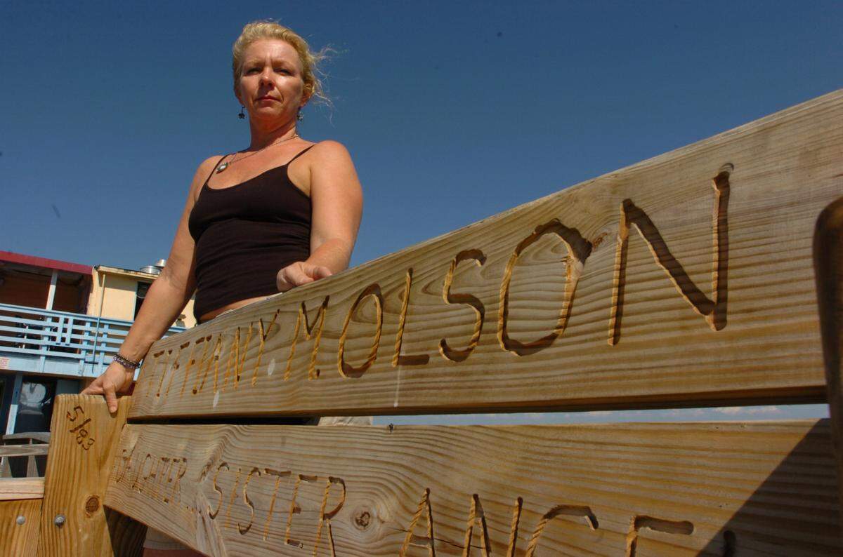 2011--Christine Olson stands next to the bench honoring her daughter, Tiffiany Olson, at Rod & Reel Pier on Anna Maria Island.