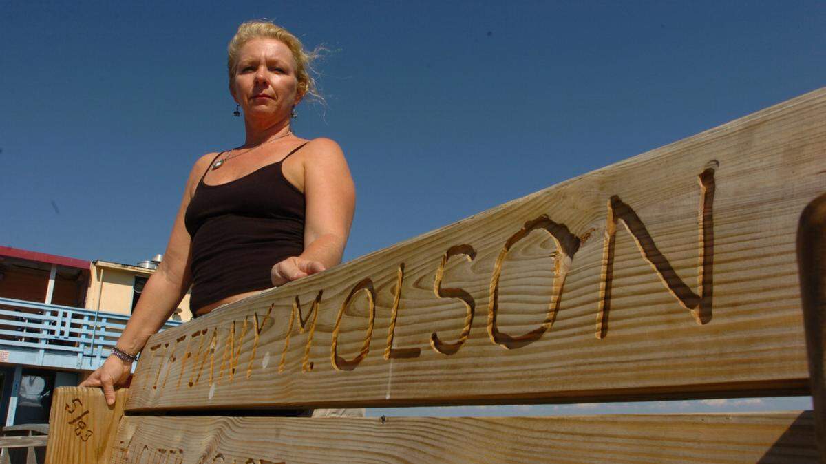 2011--Christine Olson stands next to the bench honoring her daughter, Tiffiany Olson, at Rod & Reel Pier on Anna Maria Island.