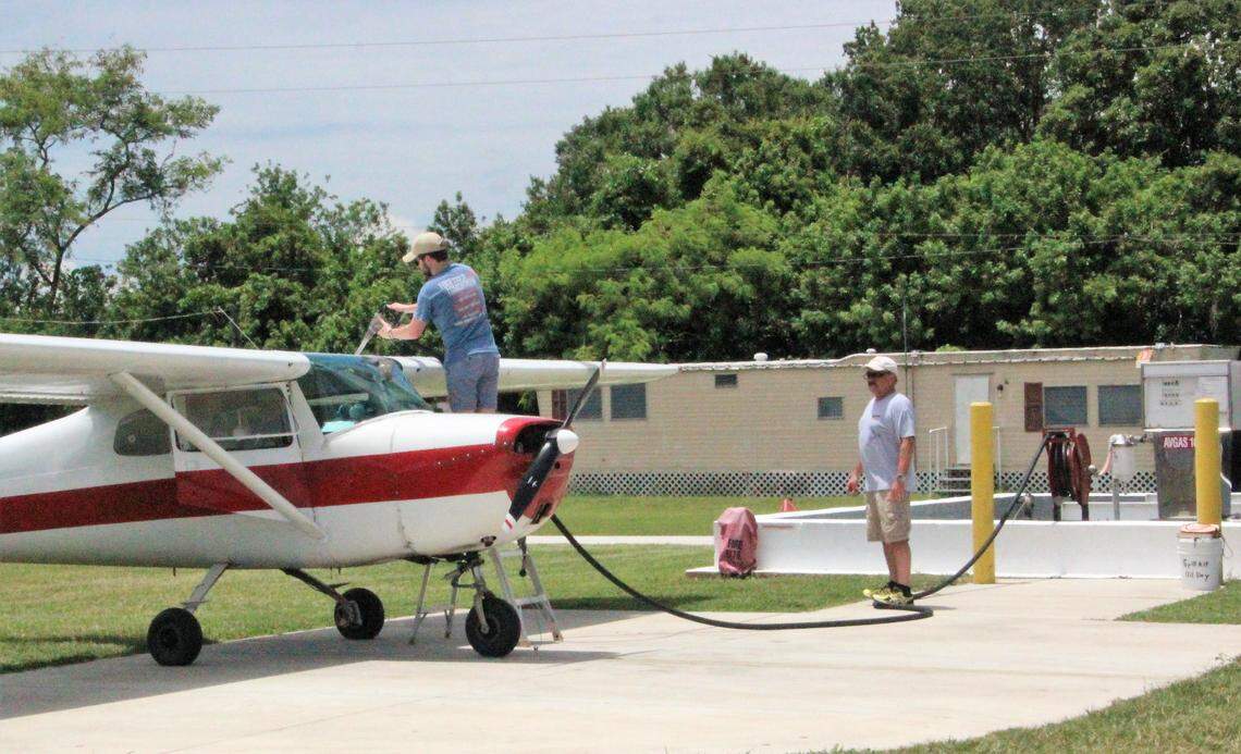 Alec MacKinnon fuels a 1963 Cessna 150 as his father, Gerry MacKinnon, watches at Airport Manatee.
