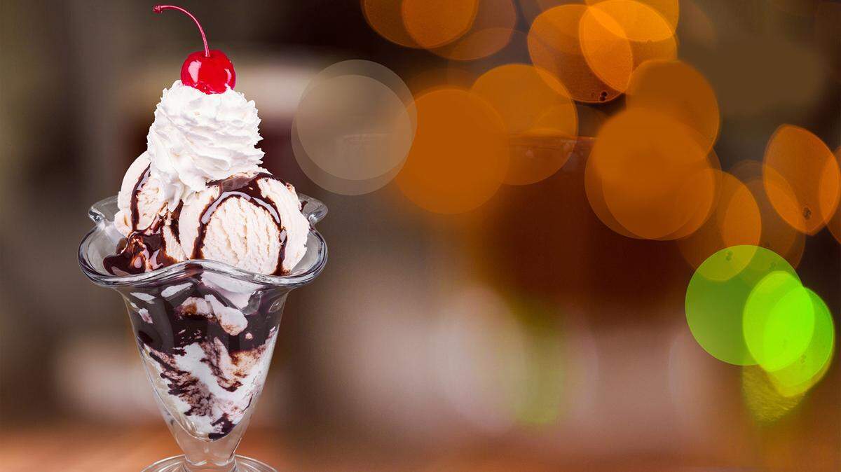 An ice cream sundae is placed and ready for eating on a counter.