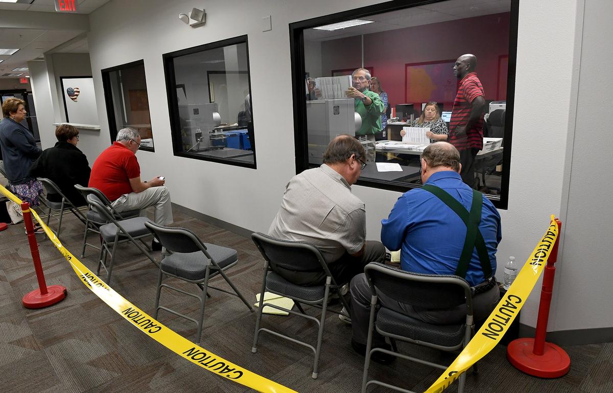 Manatee County Supervisor of Elections Mike Bennett feeds ballots into a tabulation machine Wednesday as the recount continues. One of the two tabulation machines was out of order, though the one continued the count as a repairman was called.