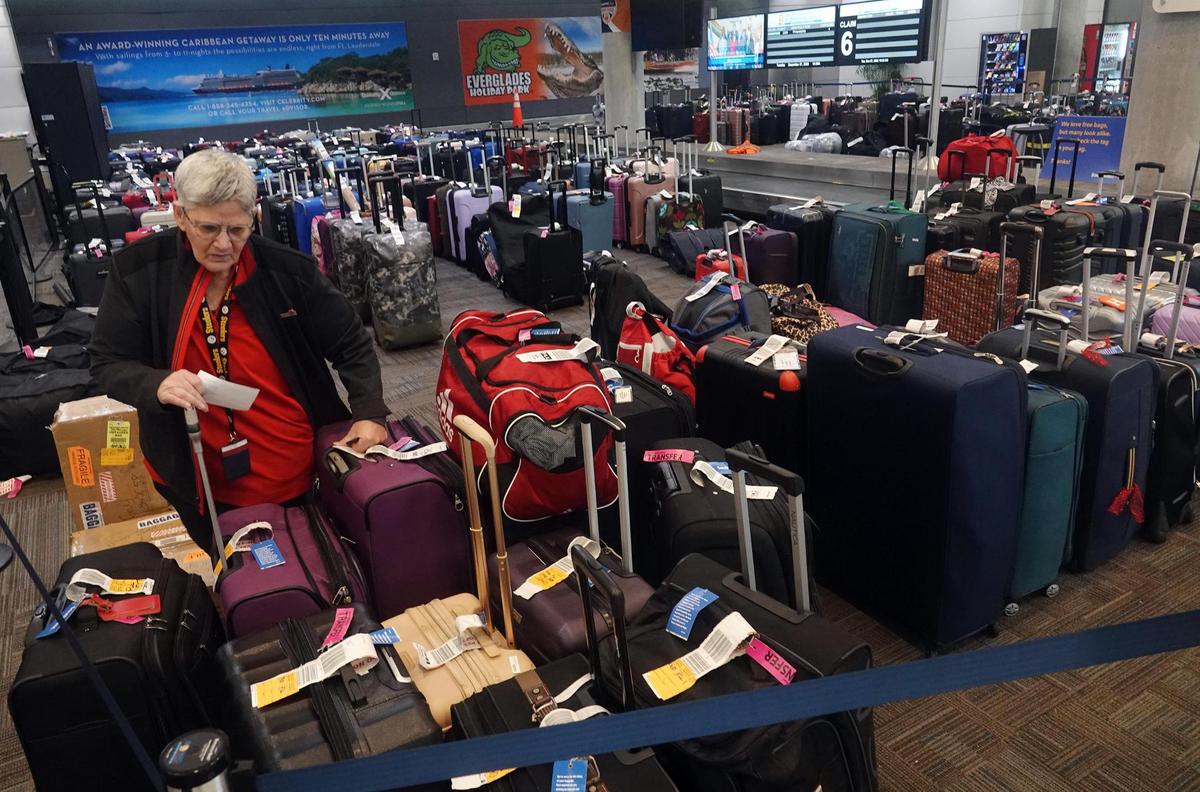 An employee of Southwest Airlines checks unclaimed and rerouted luggage on Tuesday, Dec. 27, 2022, at Fort Lauderdale-Hollywood International Airport. A brutal winter storm caused major delays in air travel across the U.S.