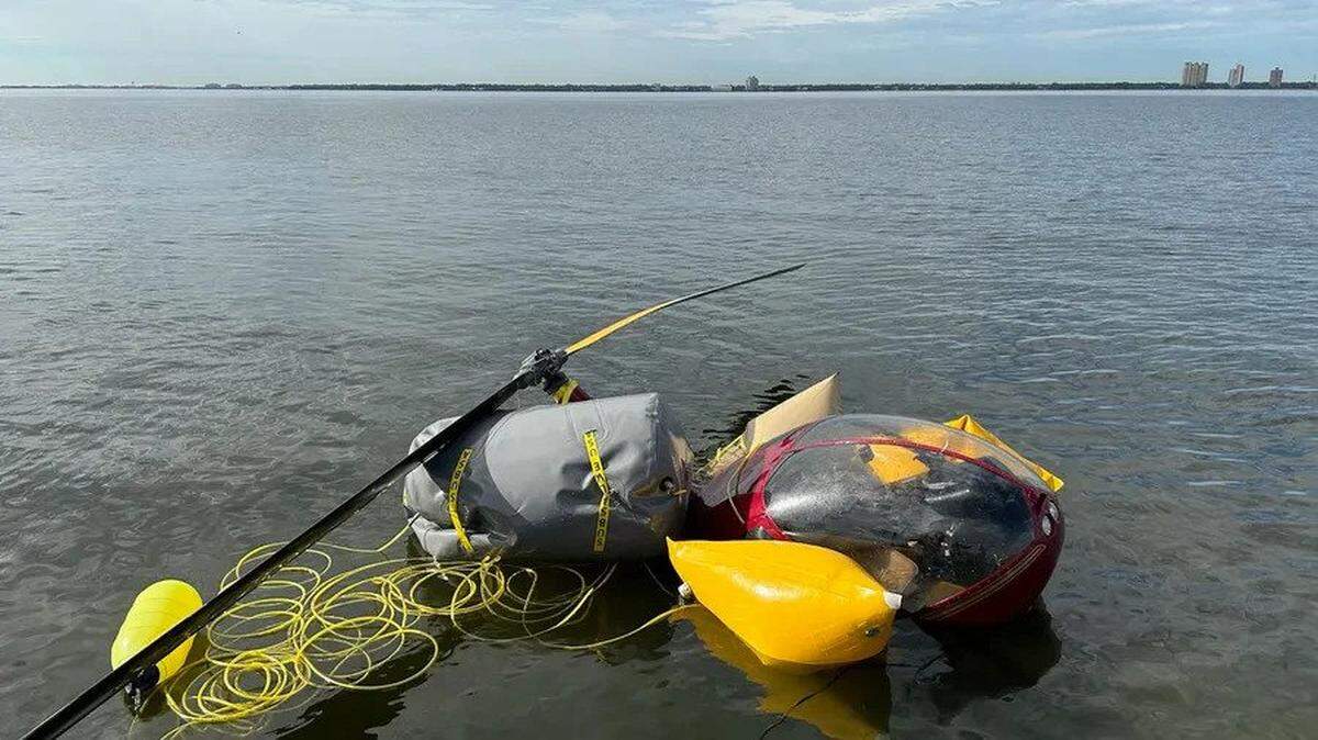 A helicopter that crashed in Tampa Bay near Peter O. Knight Airport on Davis Islands on Thursday bobs on the surface Friday, Jan. 30, 2022, after being raised by Tampa Police Department divers. The pilot and three passengers were able to escape without injury.