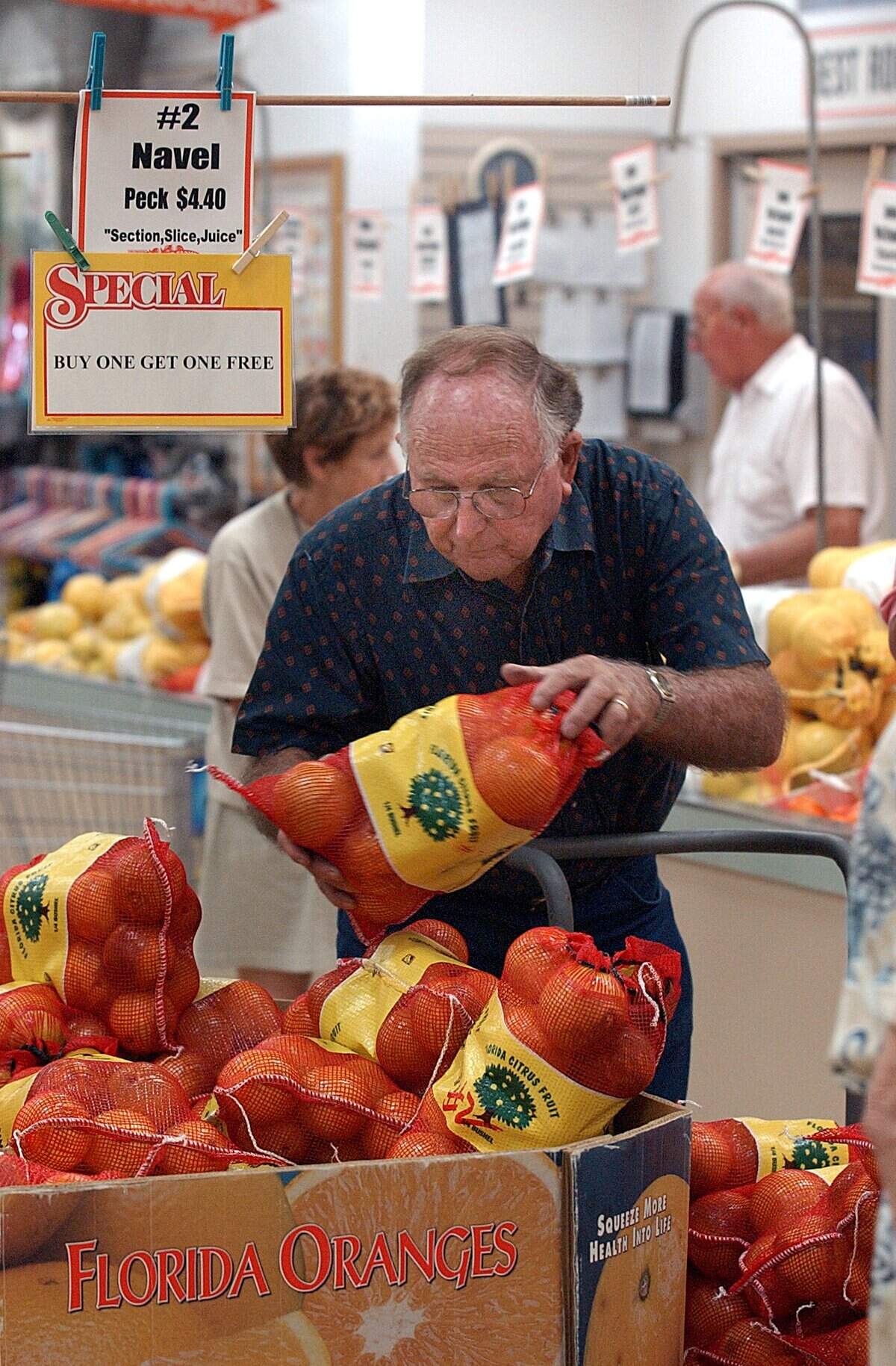 Bill Mixon stocks oranges at the annual opening of Mixon’s Fruit Farms in East Manatee in 2003.
