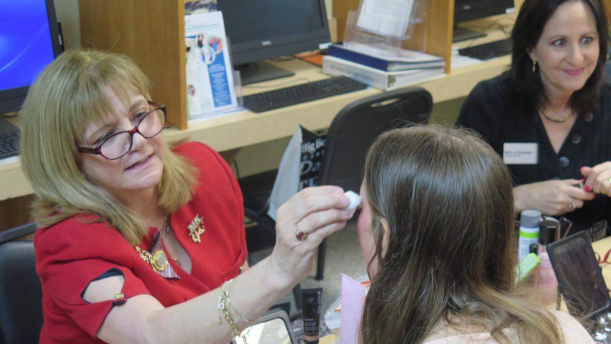 A volunteer helps layer makeup onto one of the 11 women chosen to receive a complete makeover during Saturday’s Pampering and Empowering event at Turning Points.