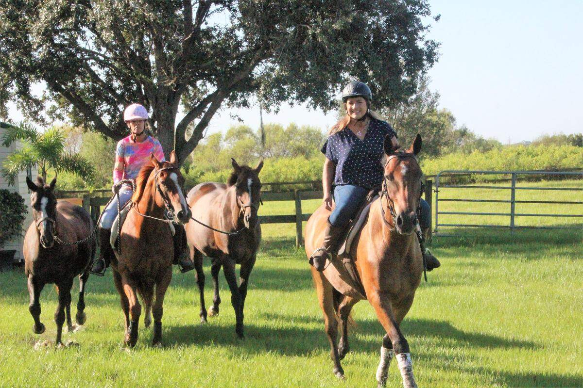 Jaymie Klauber, right, and Uli Link exercise a string of horses at Epic Equine Experiences on Wednesday. The new business offers a variety of horse related services and adventures.